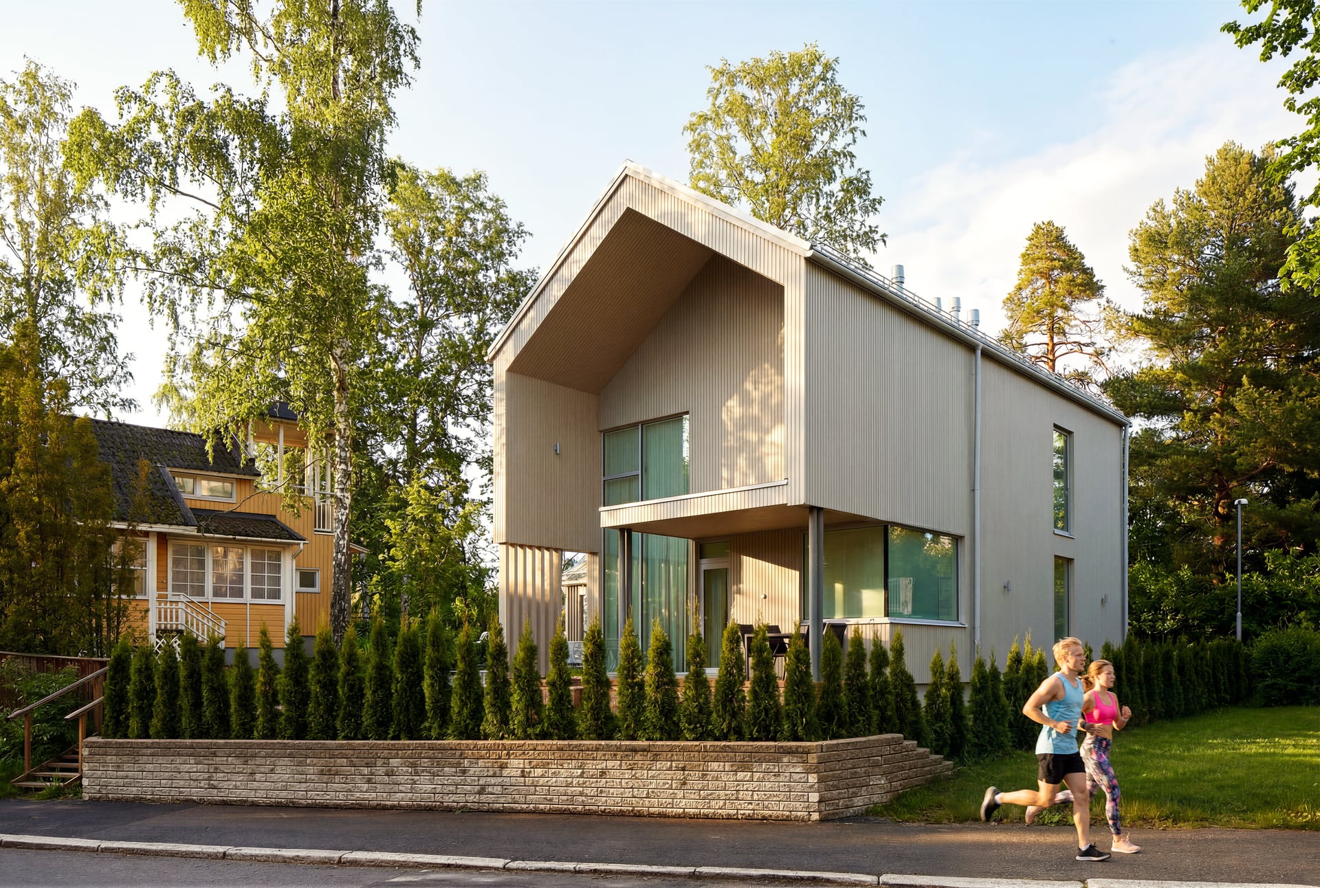 Valmis puuverhoiltu omakotitalo, lapset pihalla